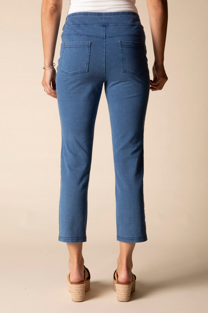 Person wearing blue jeans on a beige background