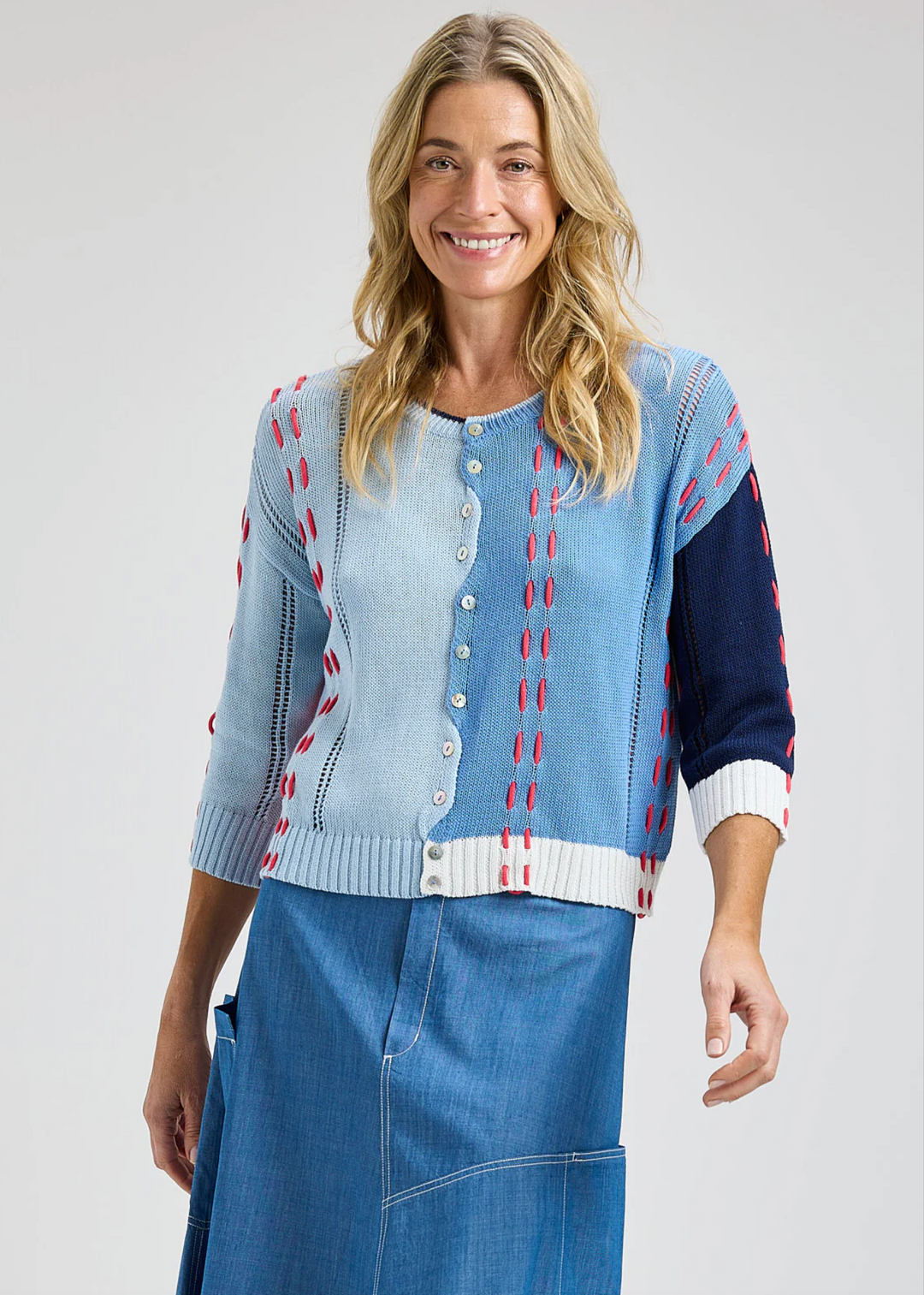 Woman wearing a blue and red patterned cardigan on a white background