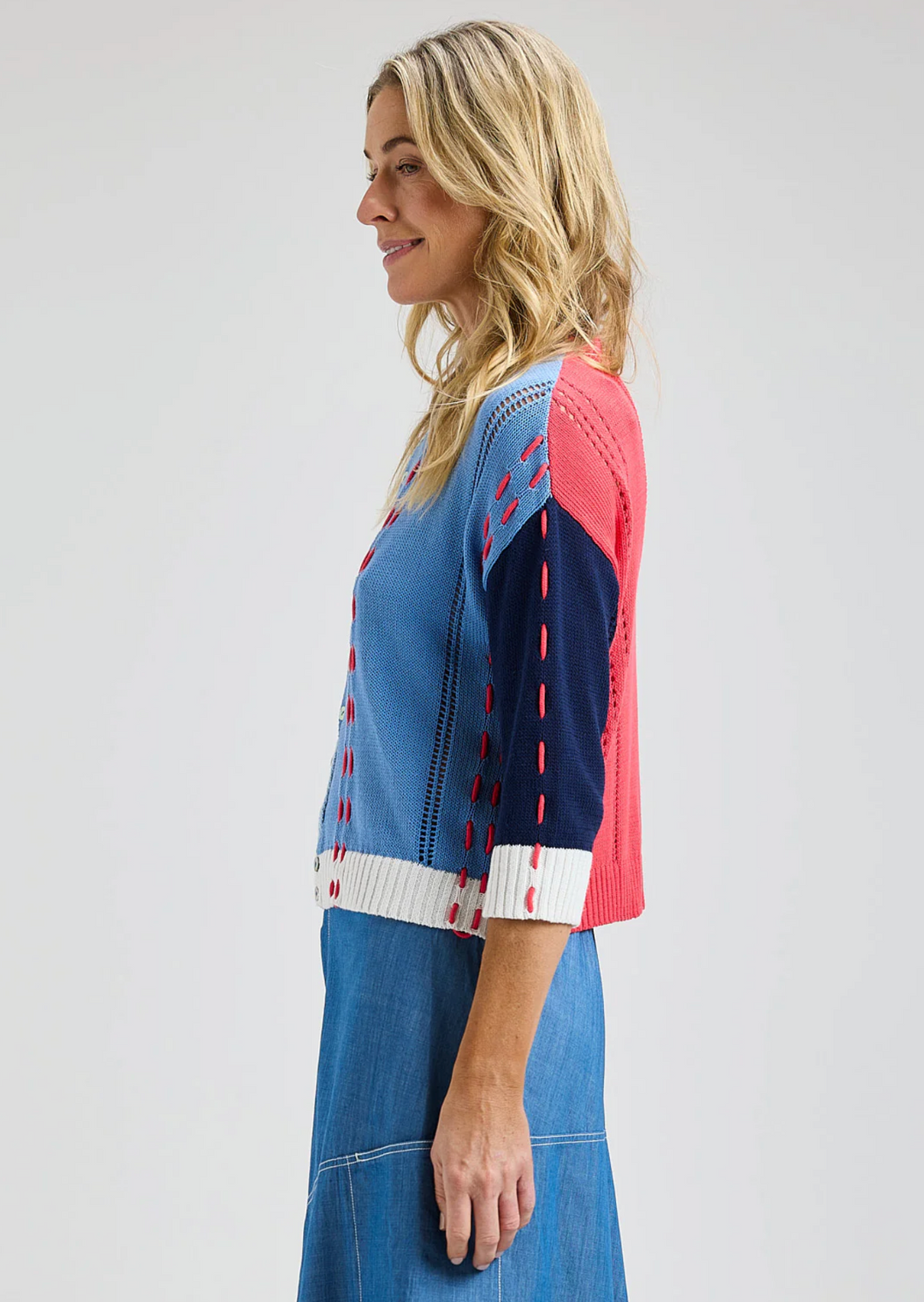 Woman wearing a blue and pink dress with a white background