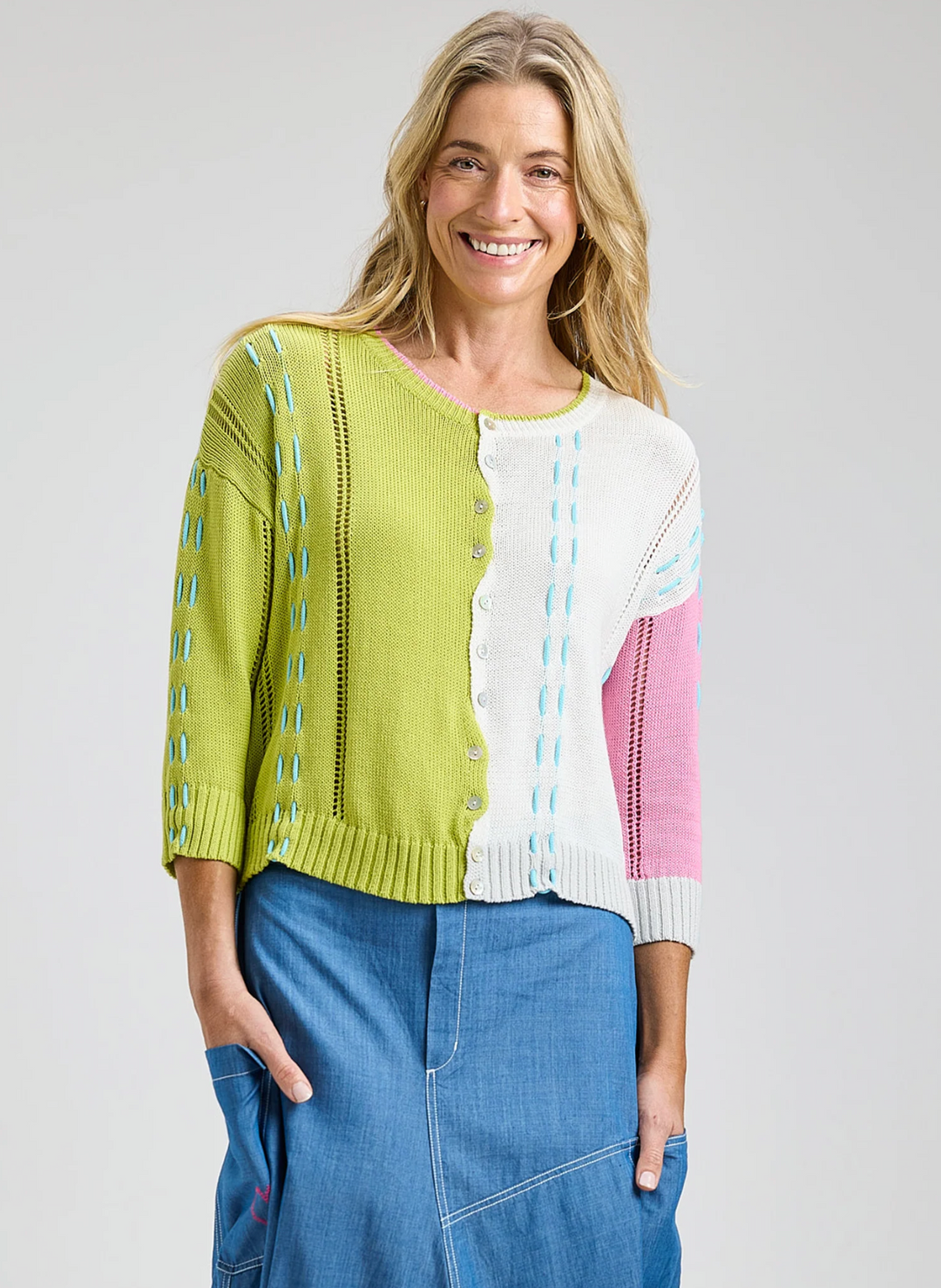 Woman wearing a colorful cardigan with a white background