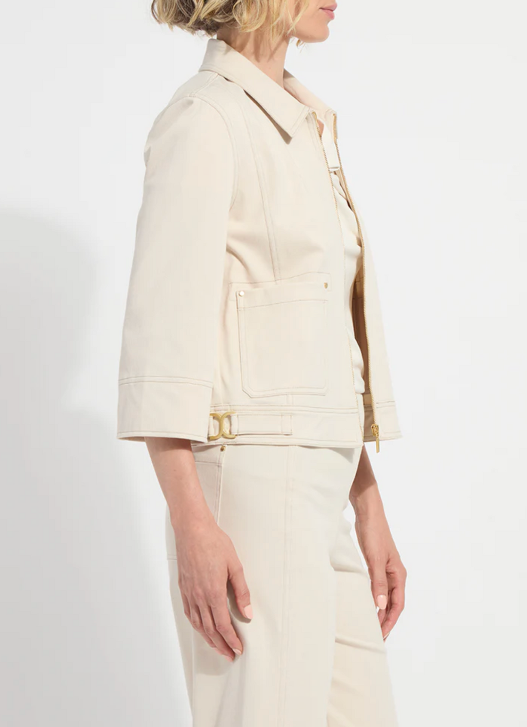 Woman wearing a cream-colored suit on a white background