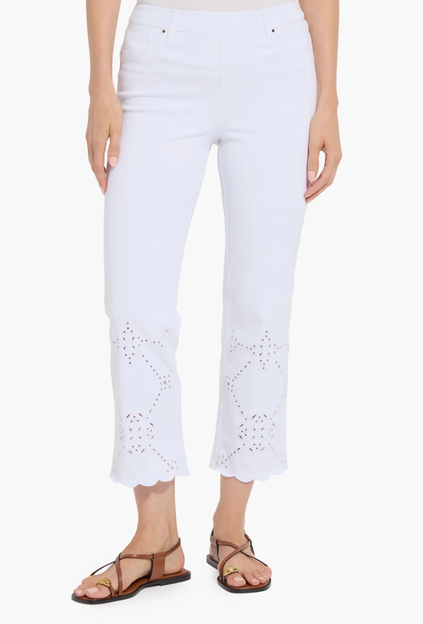 White pants with eyelet details worn by a person on a white background