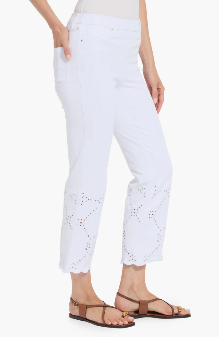 White pants with eyelet details worn by a person on a white background