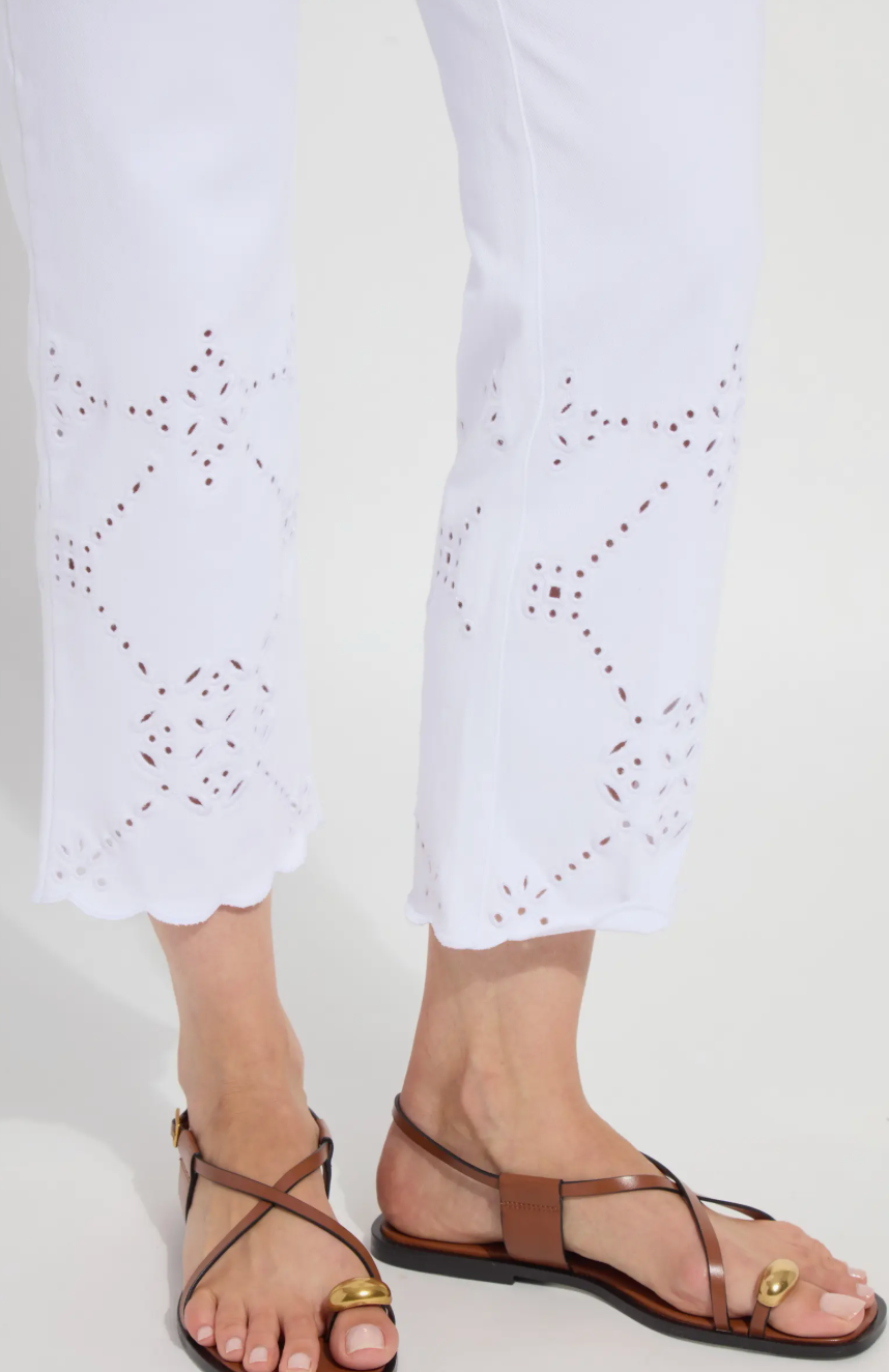 Brown sandals worn with white pants on a plain background