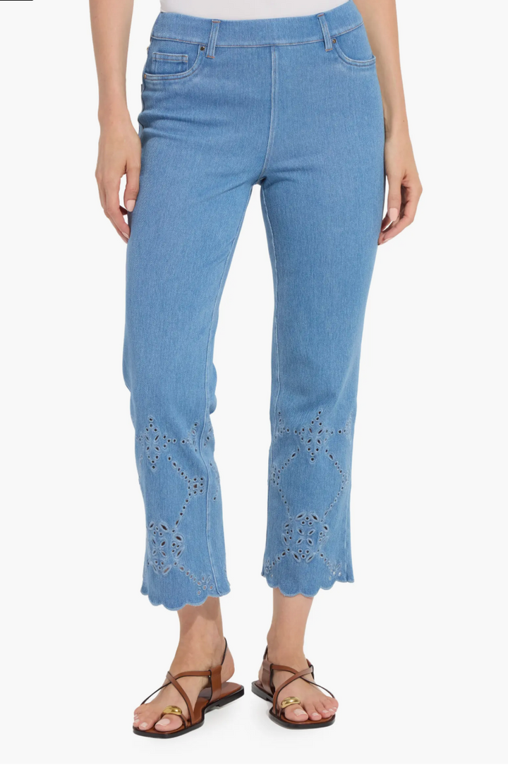 Light blue jeans with eyelet details on a white background