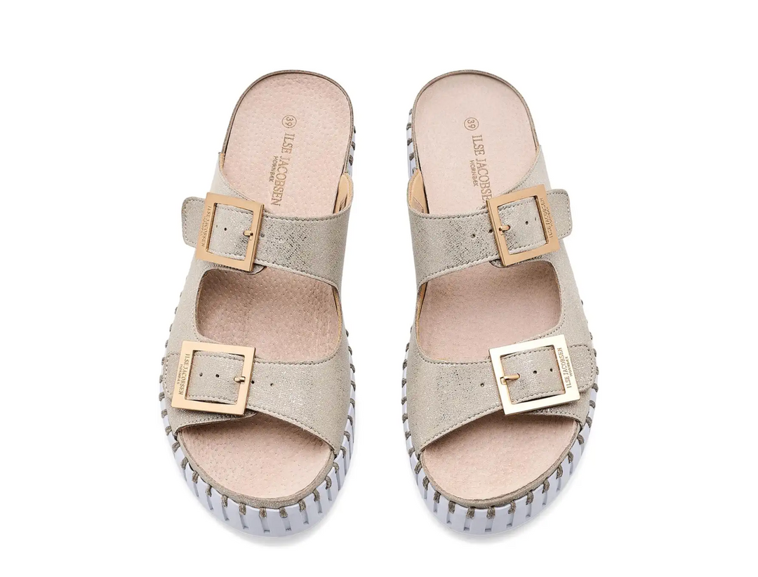 Pair of beige sandals with gold buckles on a white background