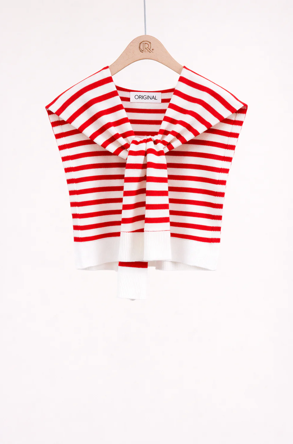 Red and white striped top on a hanger against a white background