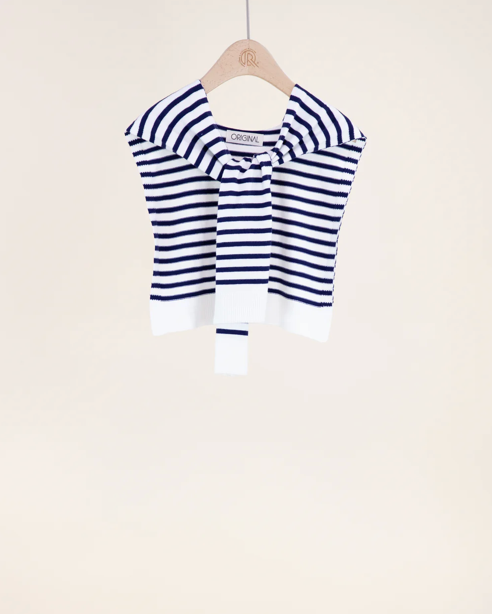 Blue and white striped garment on a hanger against a beige background