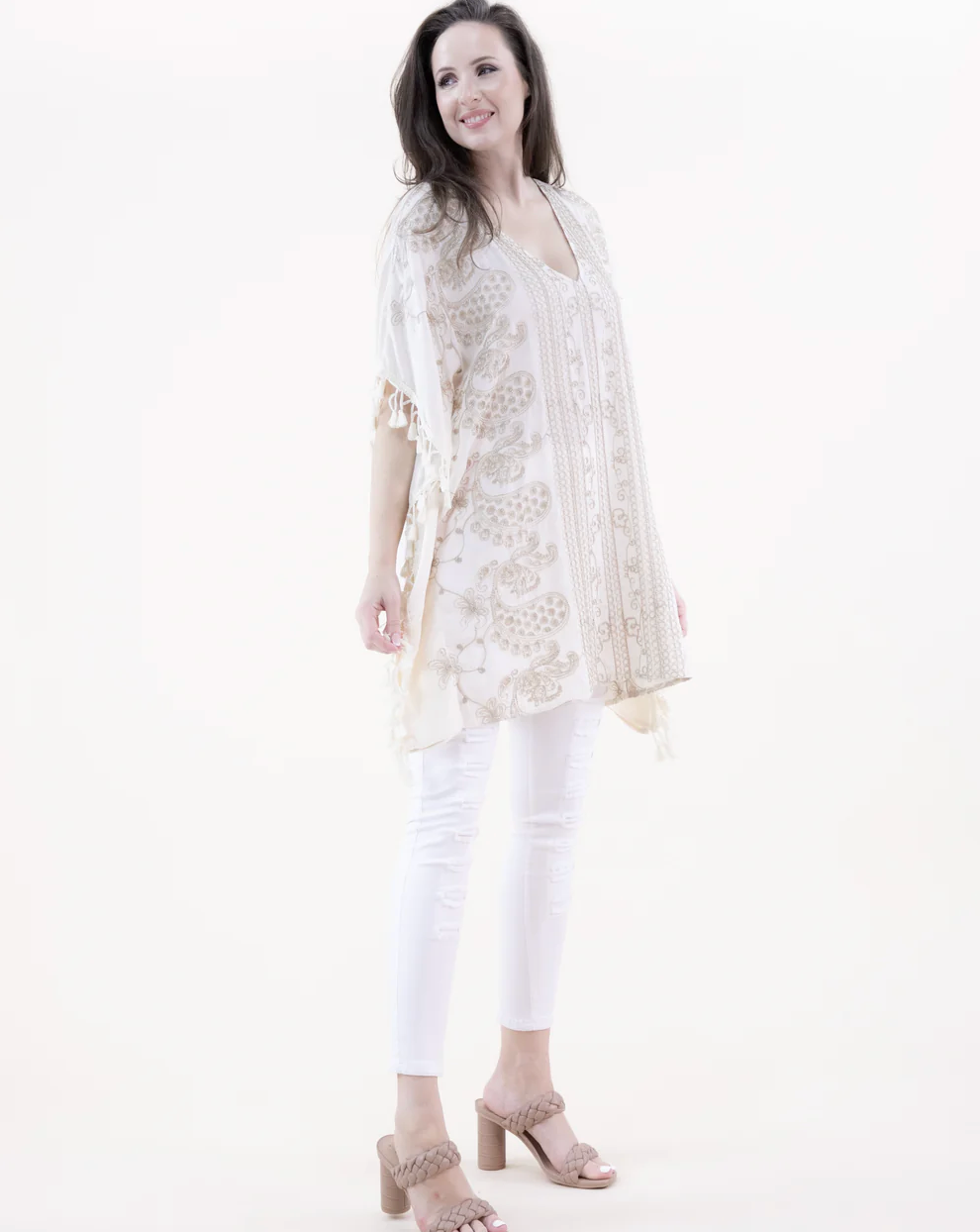 Woman wearing a white lace top and white pants on a white background