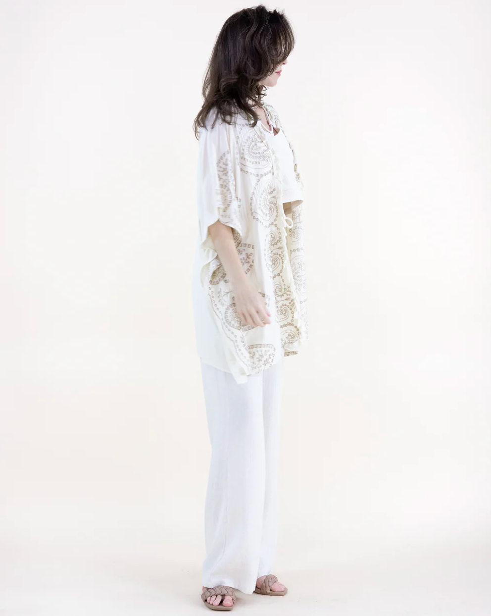 Person wearing a white lace outfit on a plain background