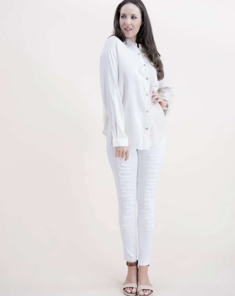 Woman wearing a white outfit on a plain background