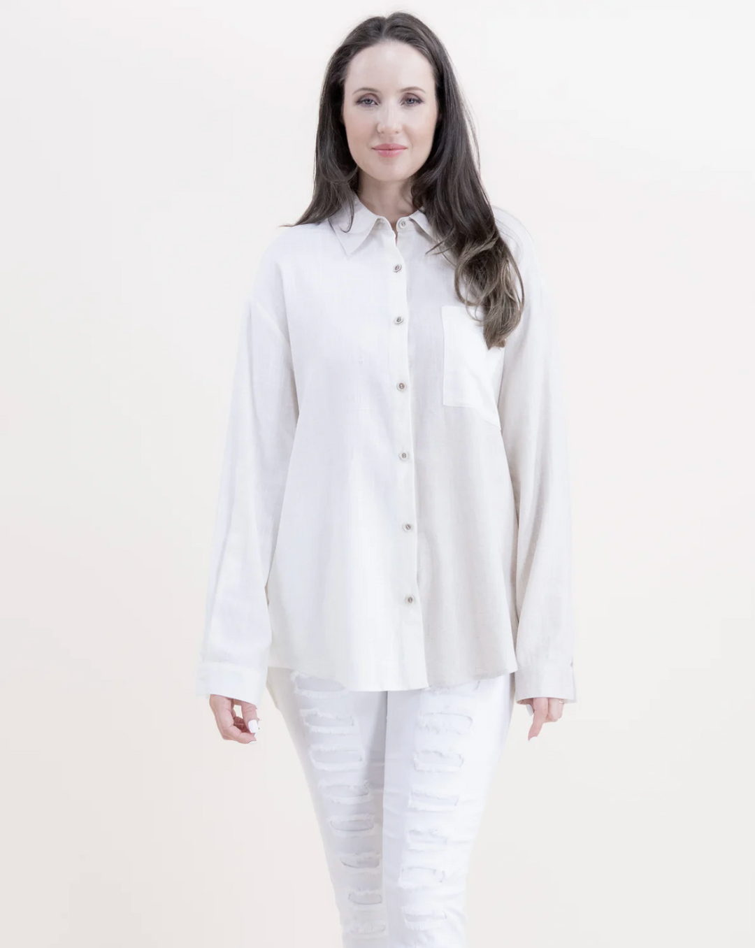 Woman wearing a white button-up shirt and pants on a white background