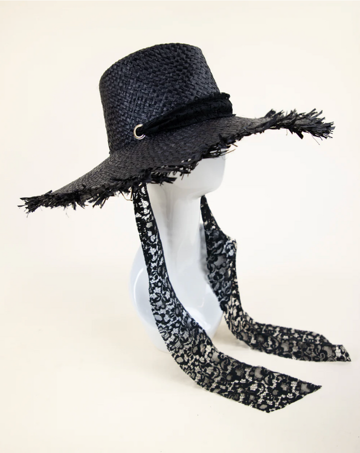 Black straw hat with decorative band and scarf on a mannequin head against a white background