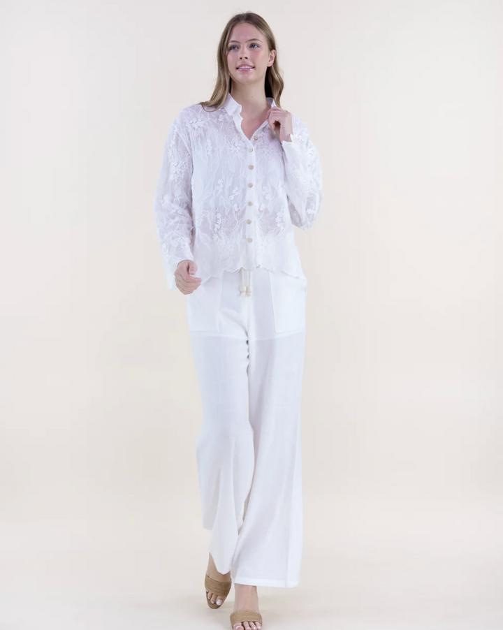 Woman wearing a white outfit on a plain background