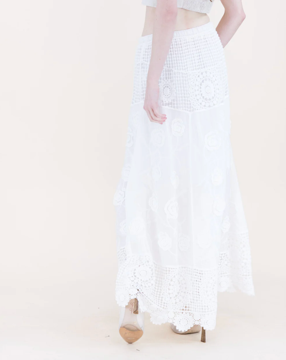 White textured skirt worn by a person on a plain background