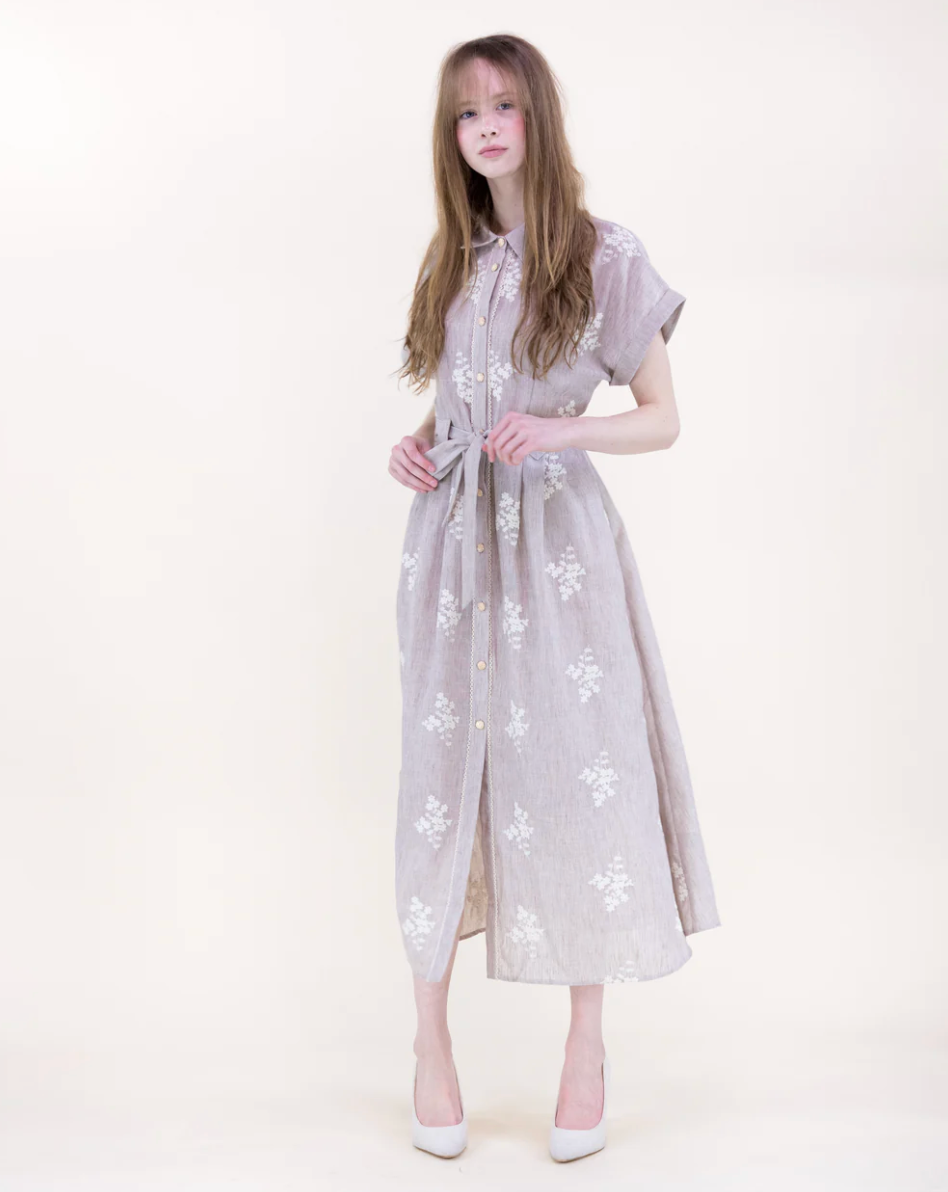 Woman wearing a dress with floral patterns on a white background