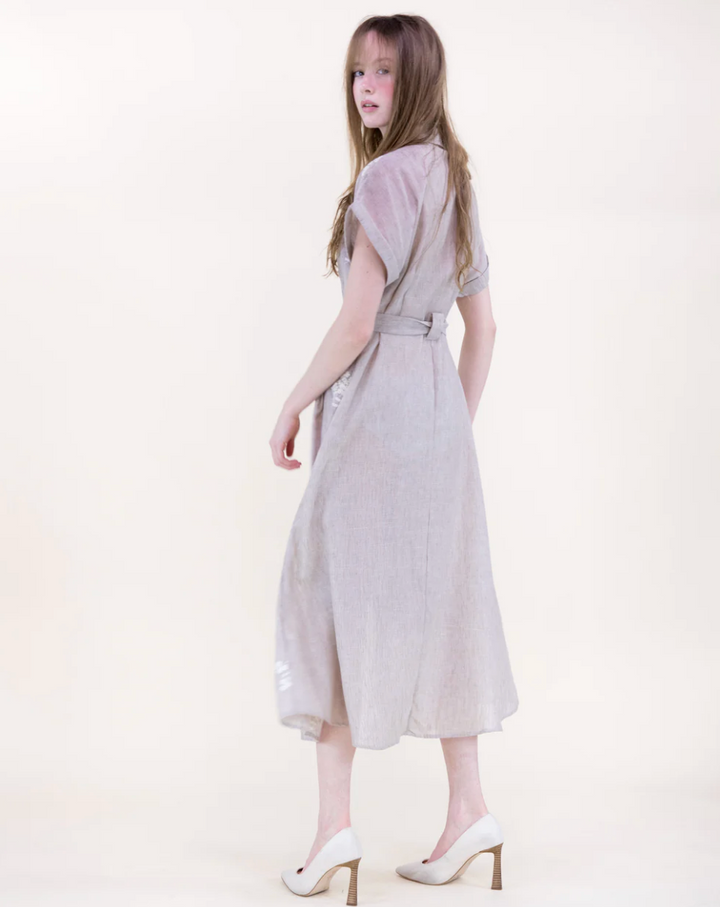 Woman wearing a beige dress on a white background