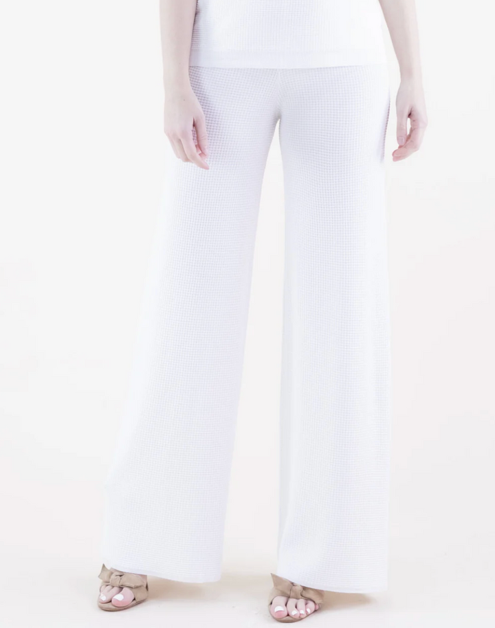White pants worn by a person on a white background