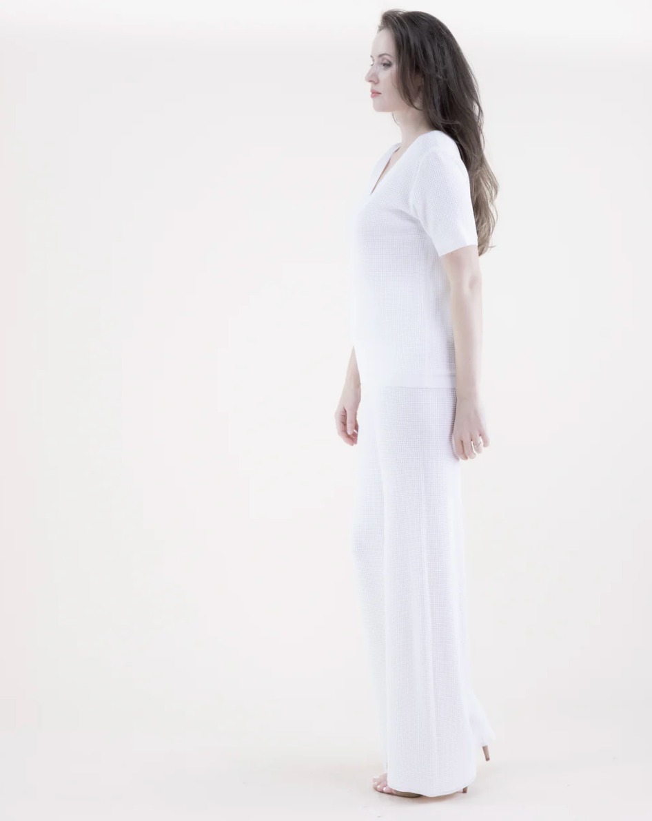 Woman wearing a white dress against a white background