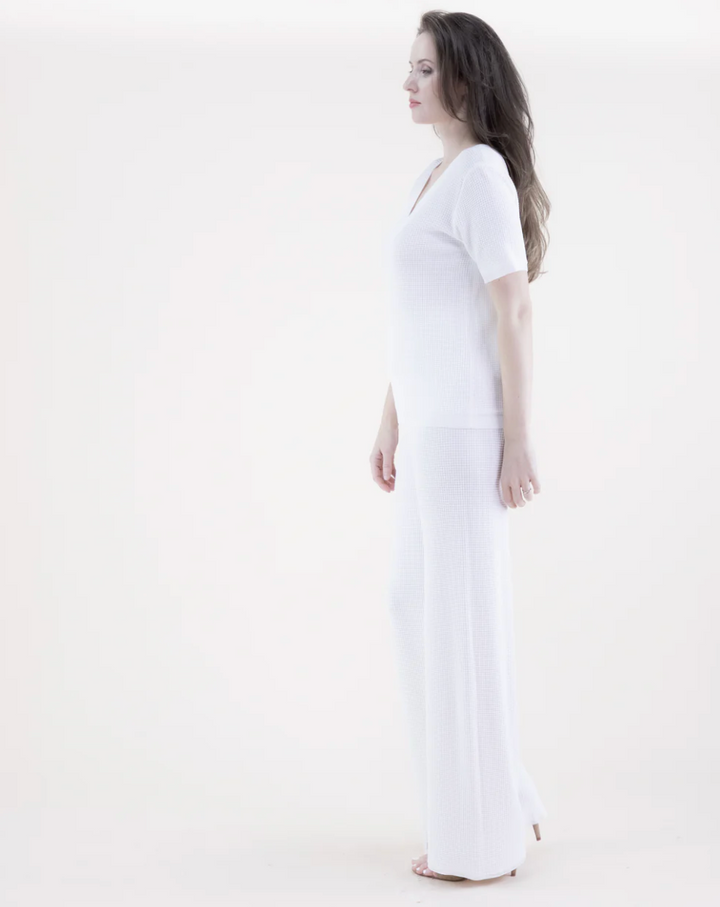 Woman wearing a white dress against a white background