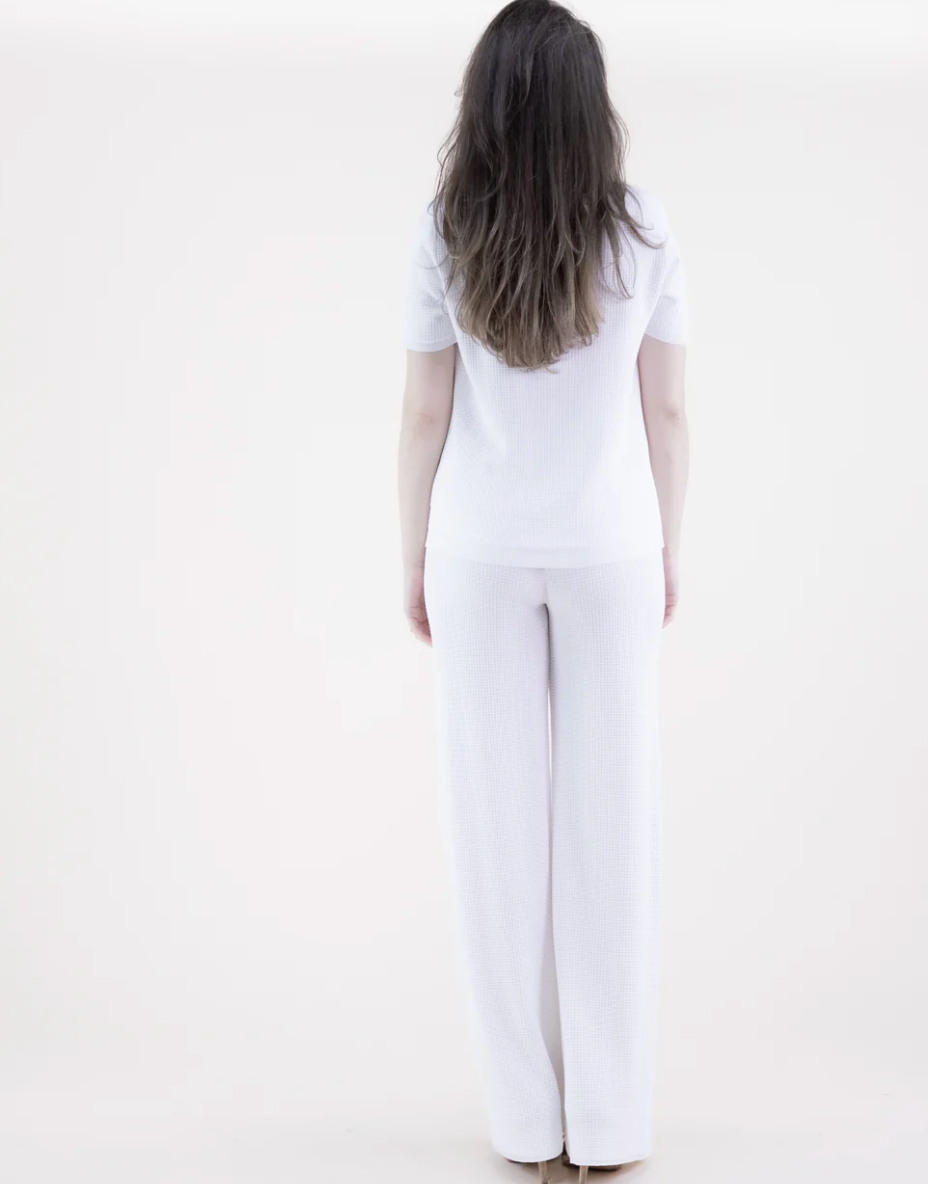 Person wearing a white outfit on a plain background