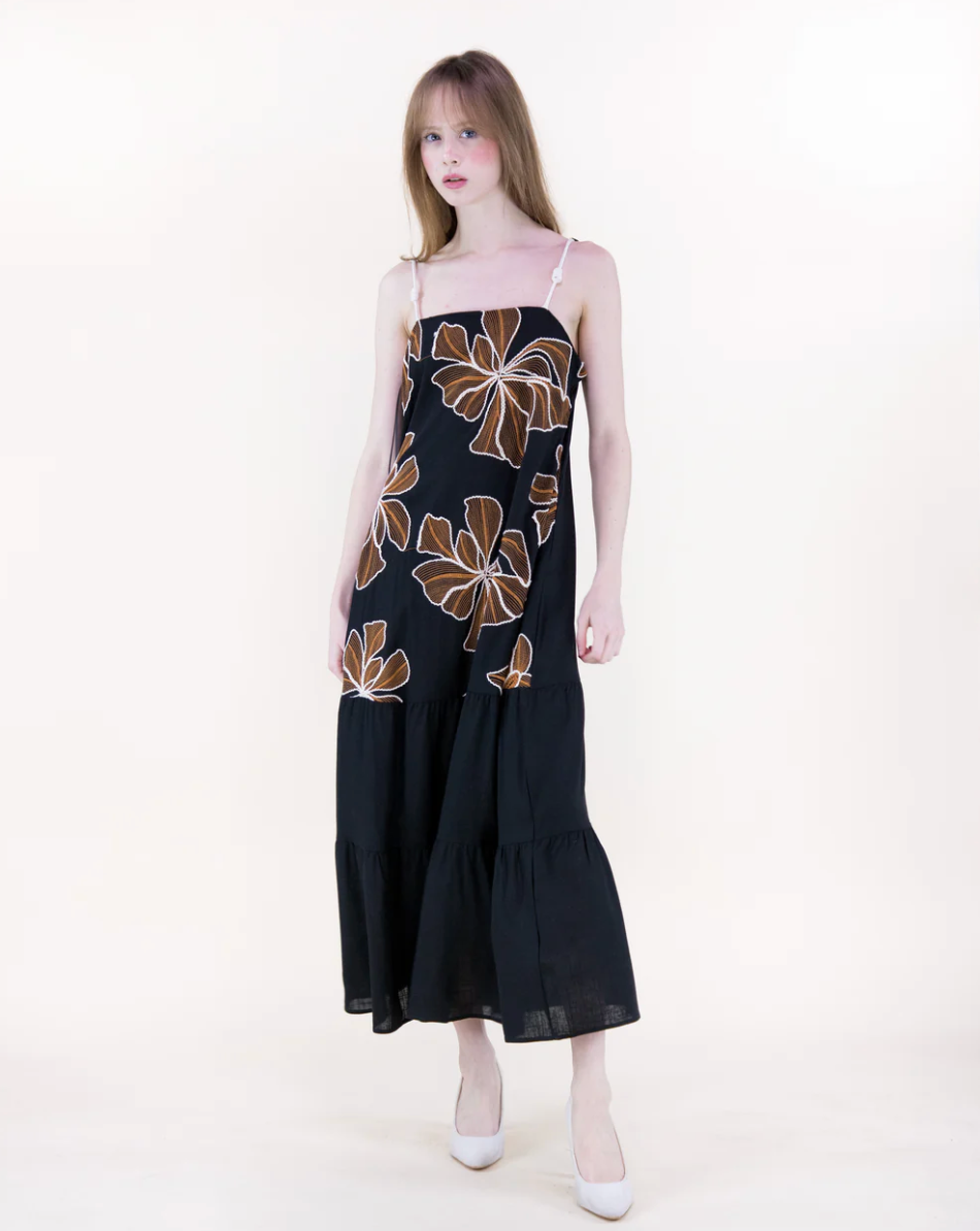 Woman wearing a black dress with floral patterns on a white background