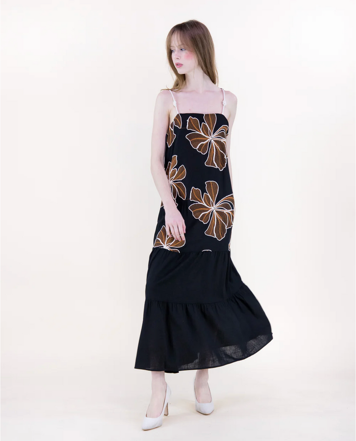 Woman wearing a black dress with floral patterns on a white background