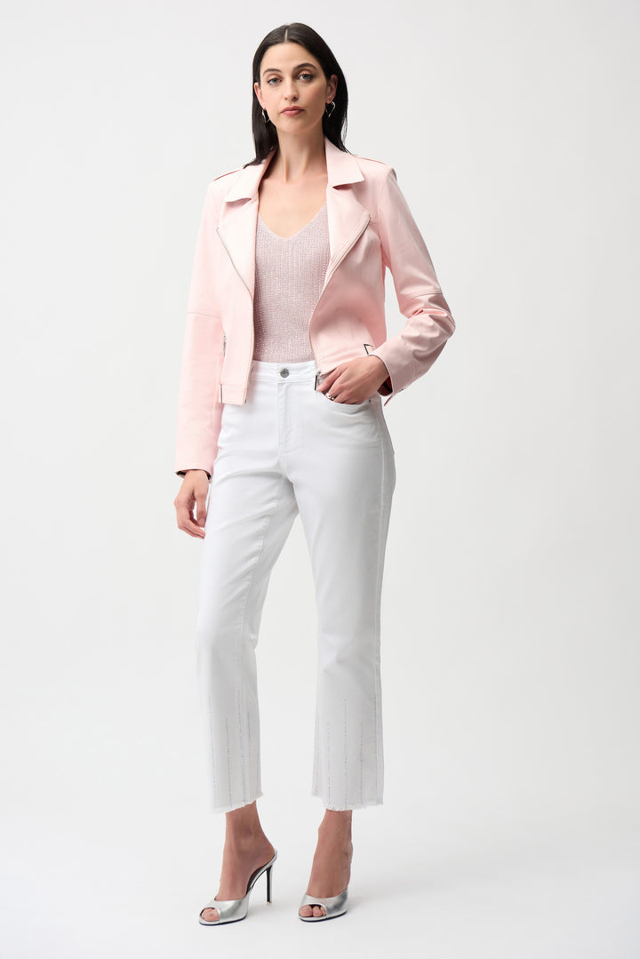 Woman wearing a pink blazer, white top, and white pants on a white background