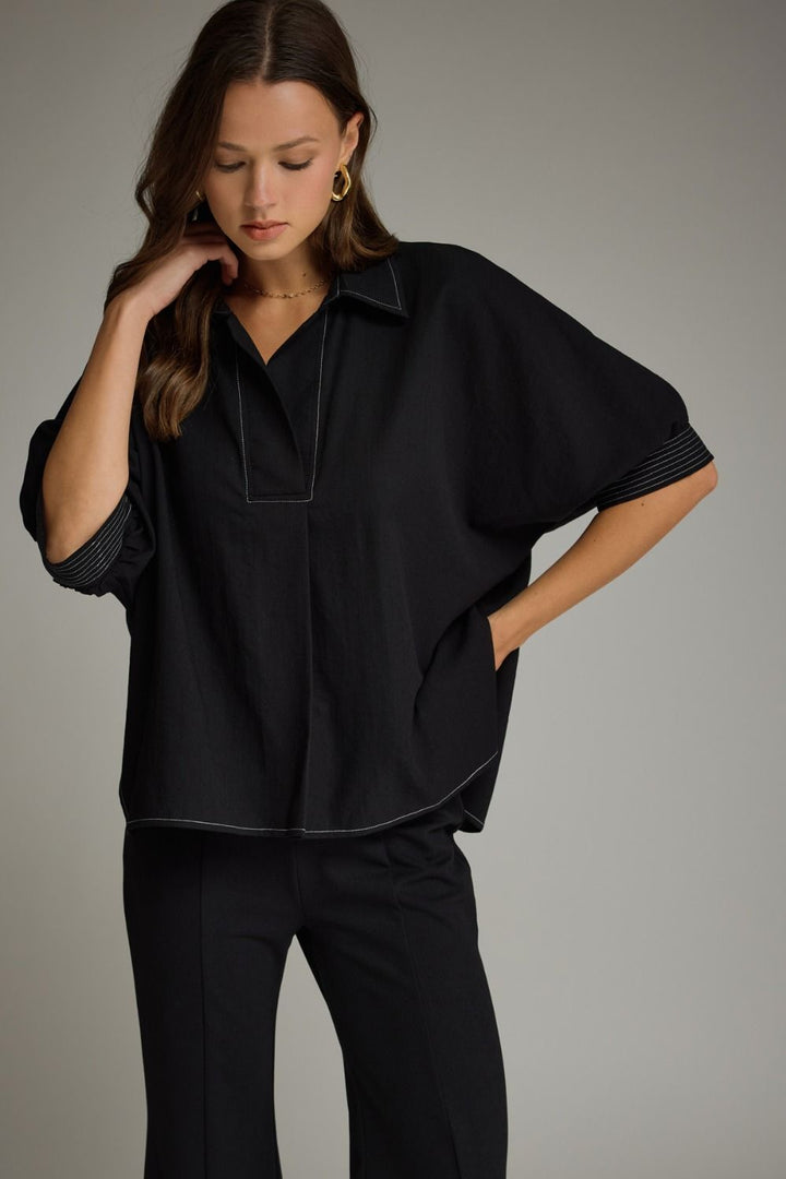 Woman wearing a black outfit against a gray background