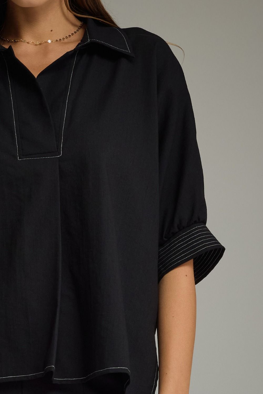 Black shirt worn by a person, close-up on the collar and sleeve.