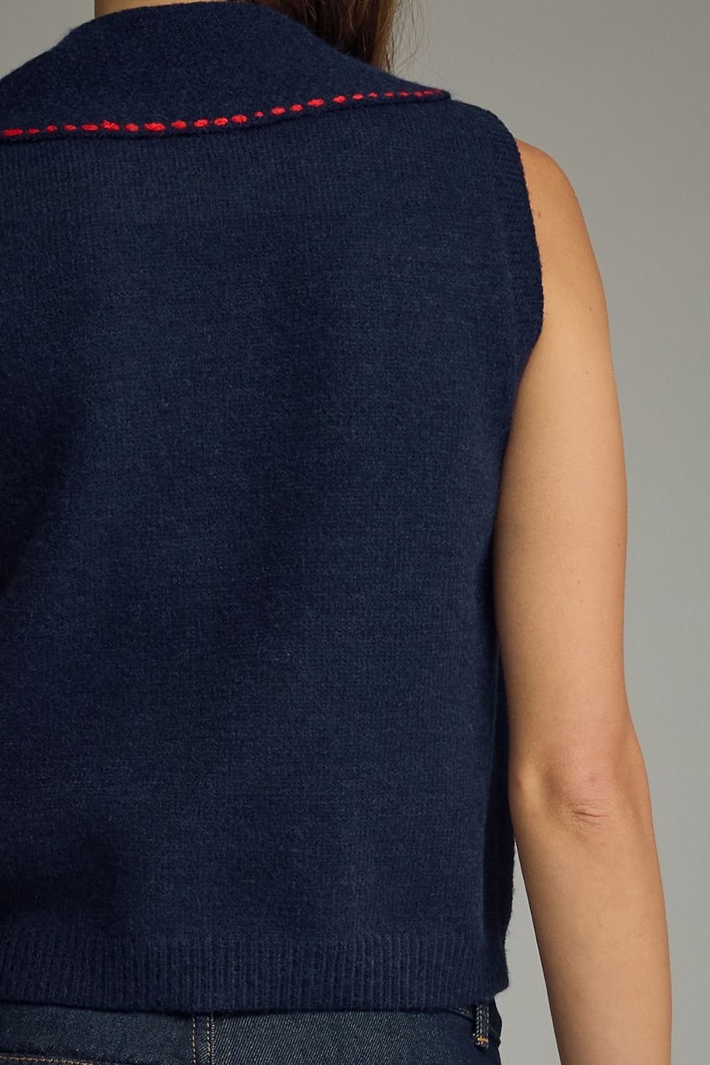 Navy blue vest with red stitching on a neutral background