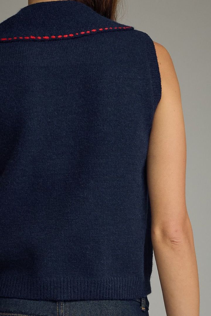 Navy blue vest with red stitching on a neutral background