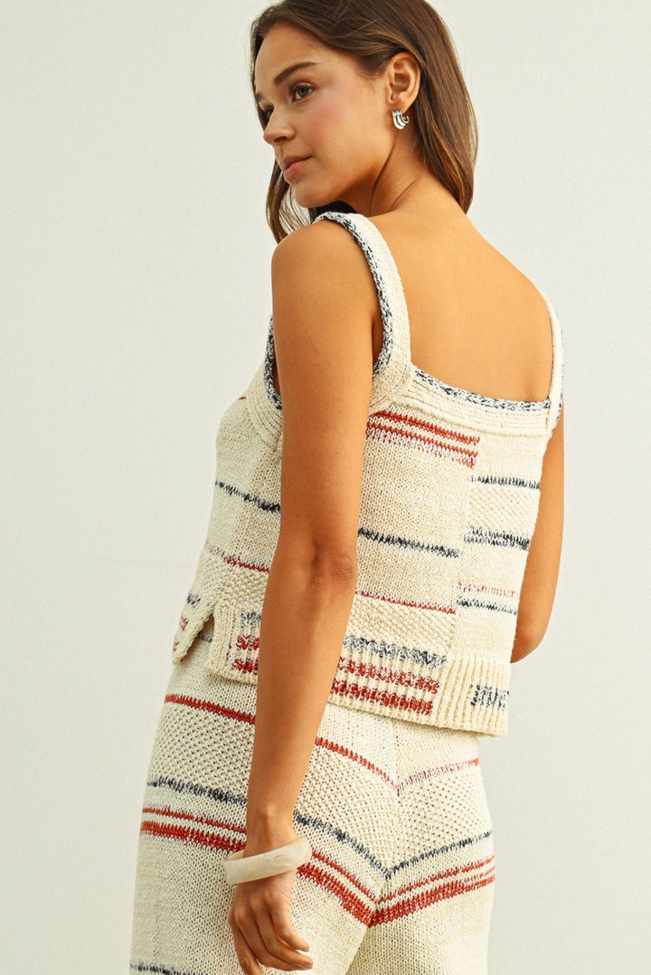 Woman wearing a striped sleeveless top on a plain background