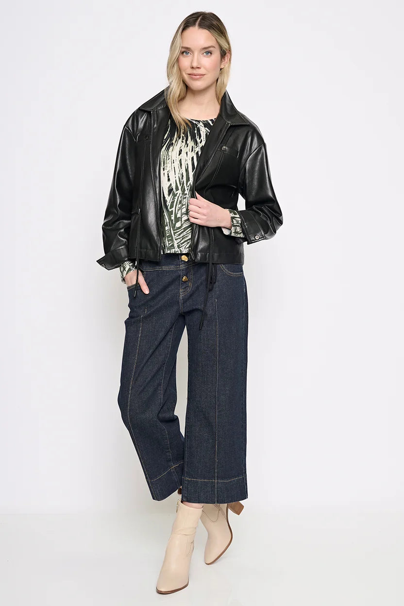 Full-length view of the black Rebel Faux Leather Jacket styled open over a printed blouse with wide-leg cropped jeans and cream ankle boots