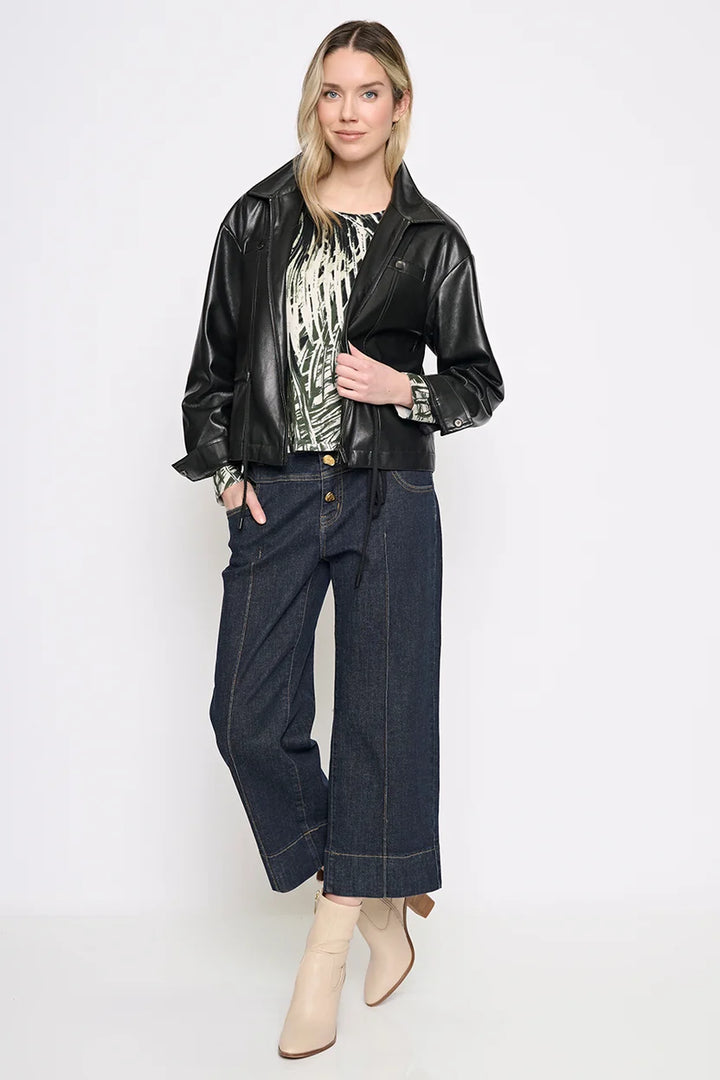 Full-length view of the black Rebel Faux Leather Jacket styled open over a printed blouse with wide-leg cropped jeans and cream ankle boots