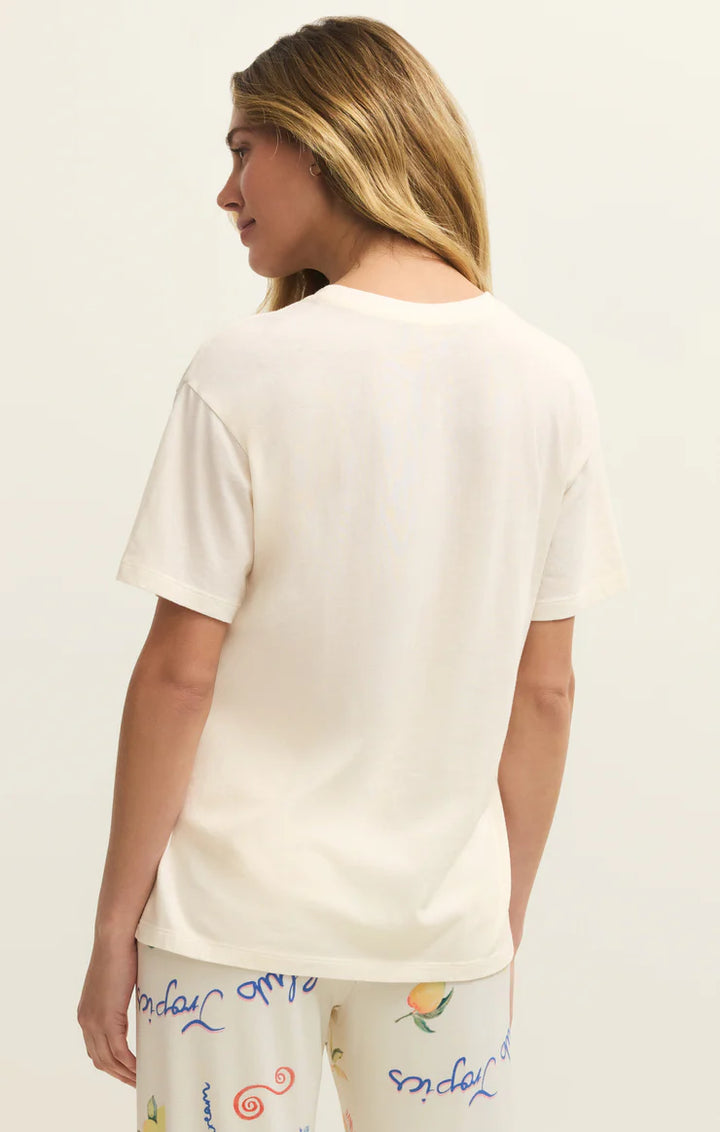 Woman wearing a plain white t-shirt with colorful text on the bottom, against a light background