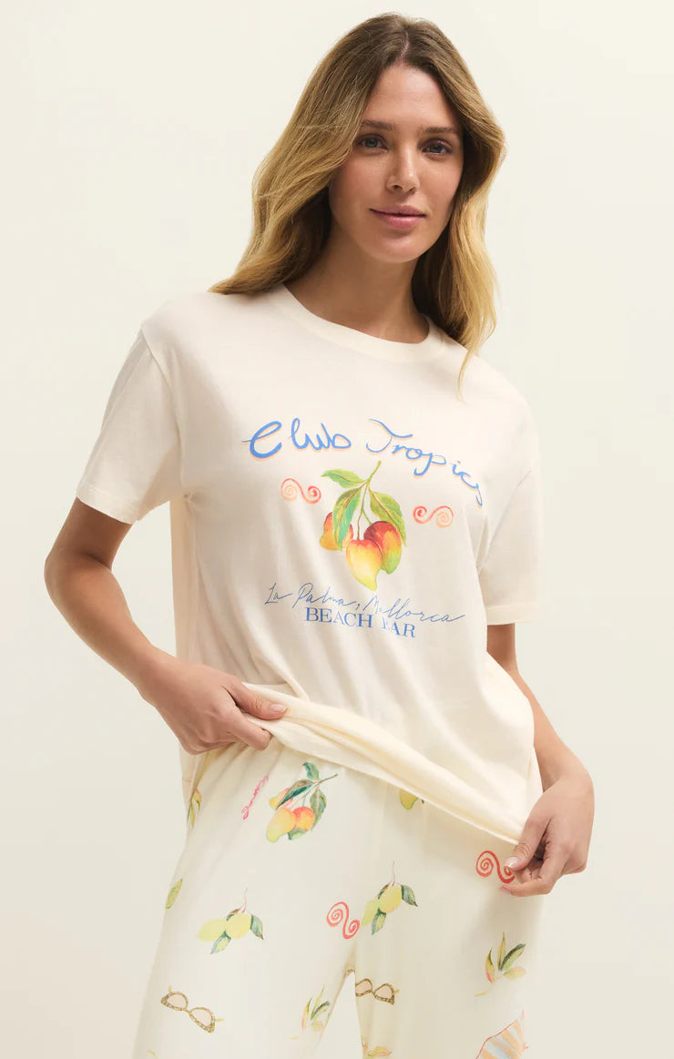 Woman wearing a cream-colored t-shirt with fruit design and text on a plain background