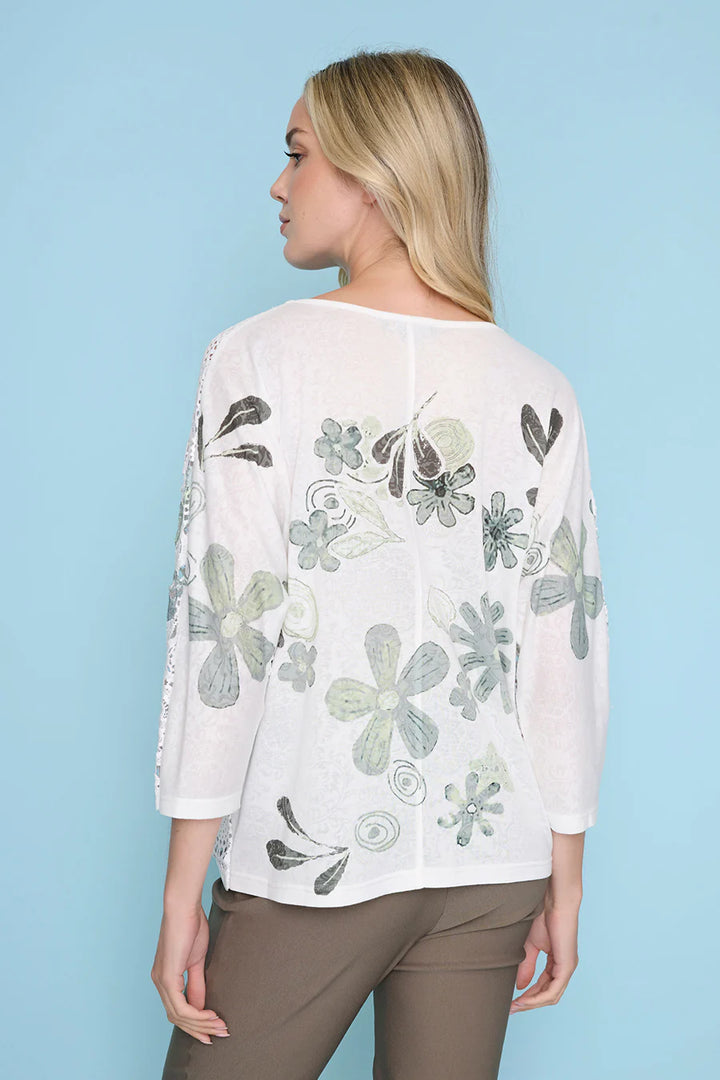 Woman wearing a white blouse with floral patterns on a light blue background