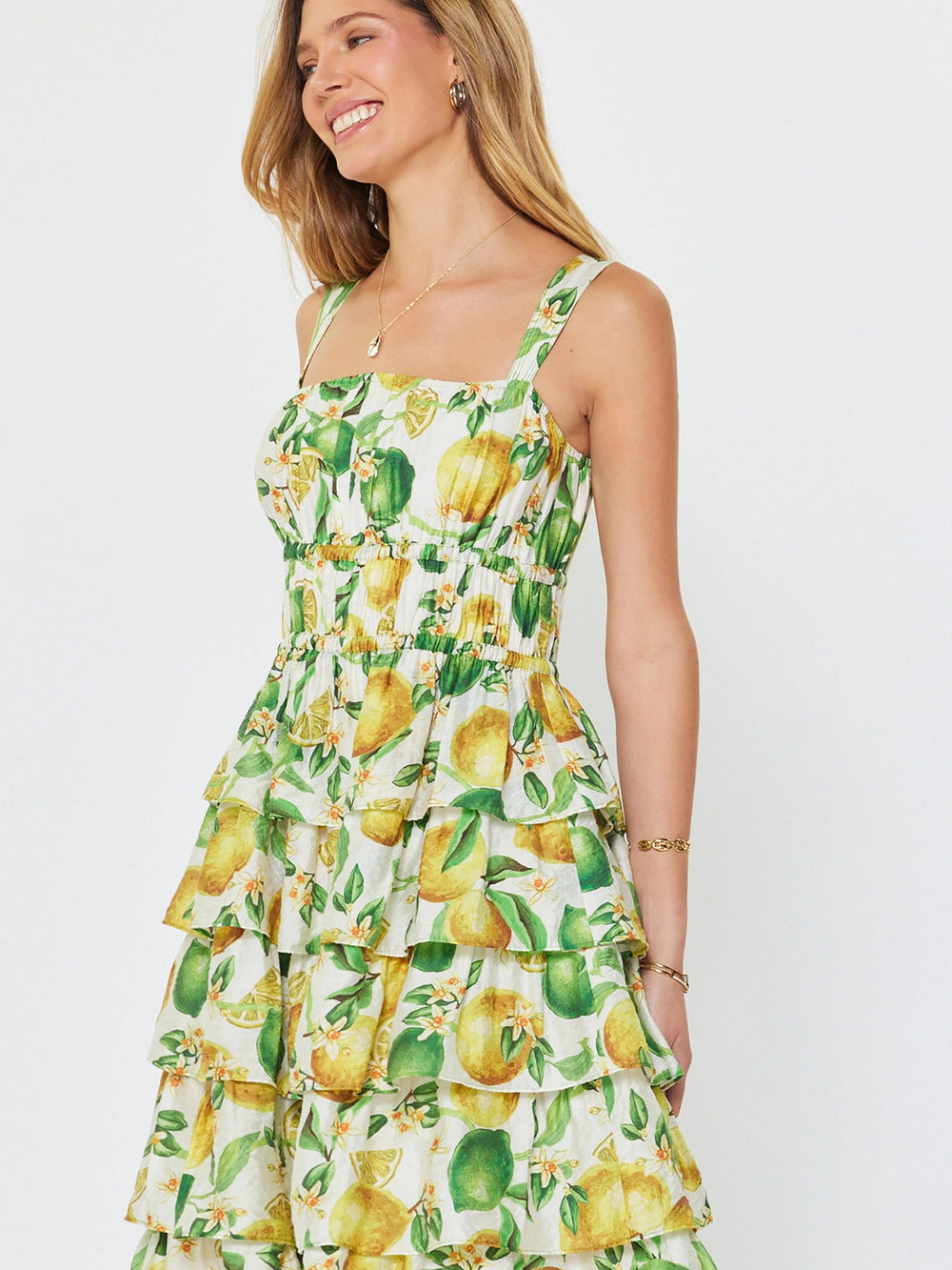 Woman wearing a lemon print dress on a white background