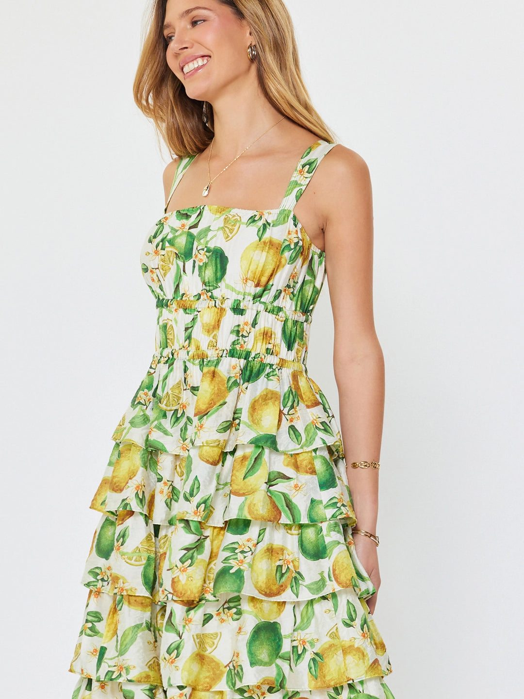 Woman wearing a lemon print dress on a white background