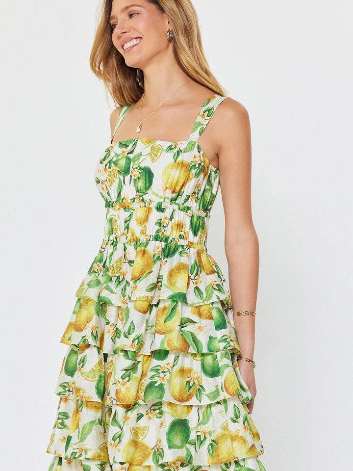 Woman wearing a lemon print dress on a white background