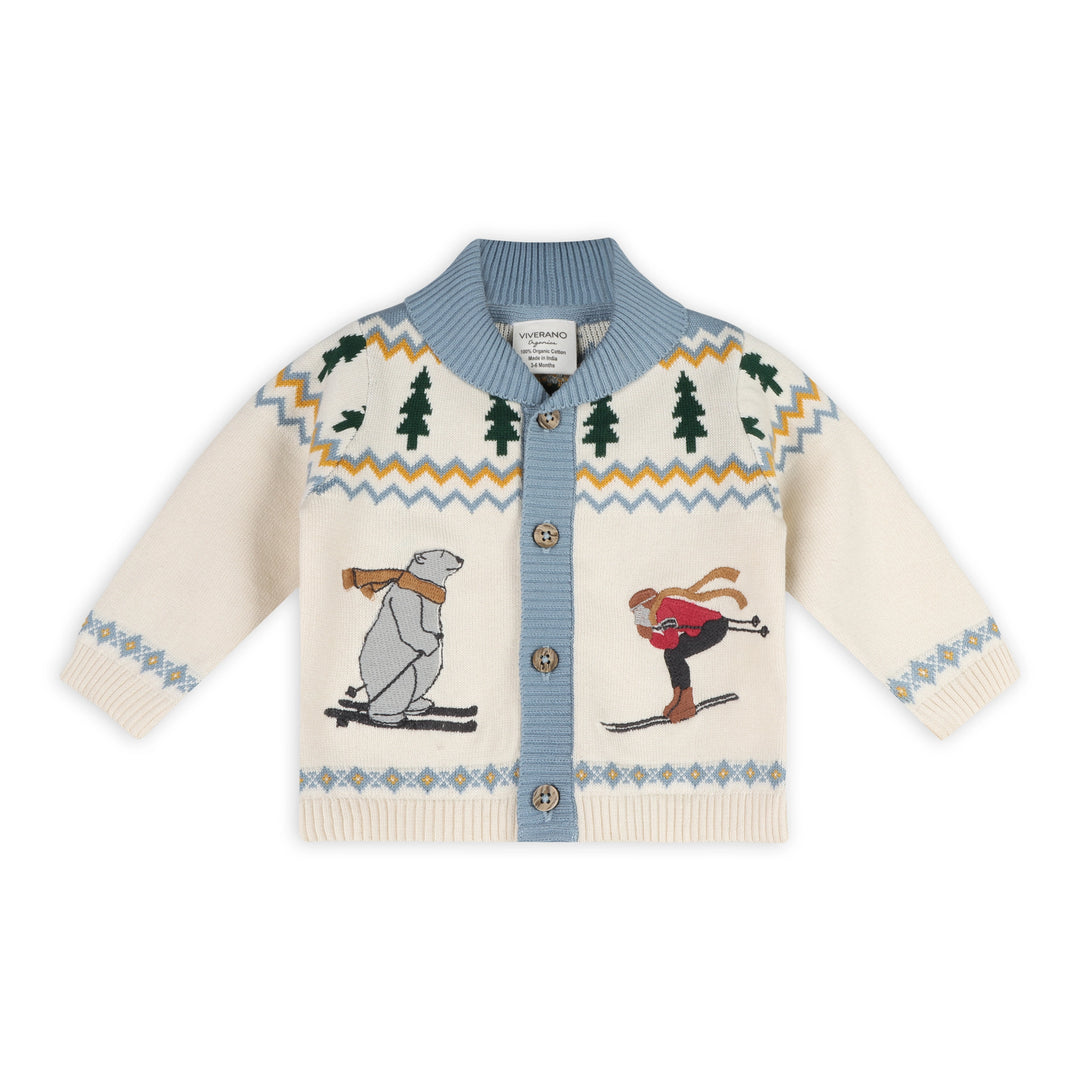 Alpine Snow Baby Cardigan in natural organic cotton knit with skiing figures and evergreen trees