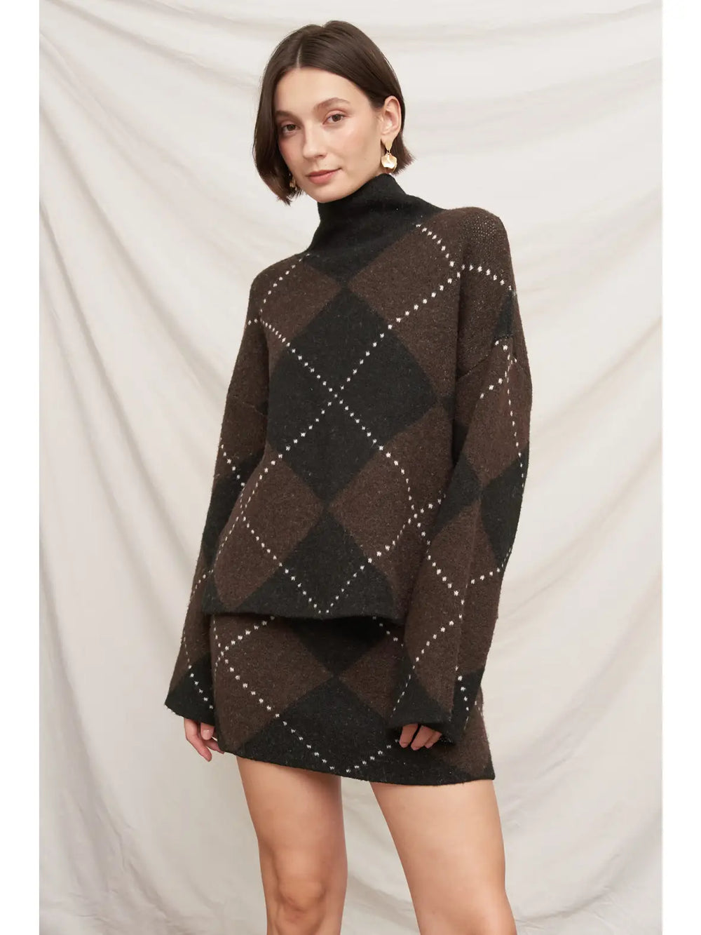 Autumn Argyle Sweater in brown and black argyle, front view styled with the matching Autumn Argyle Sweater Skirt
