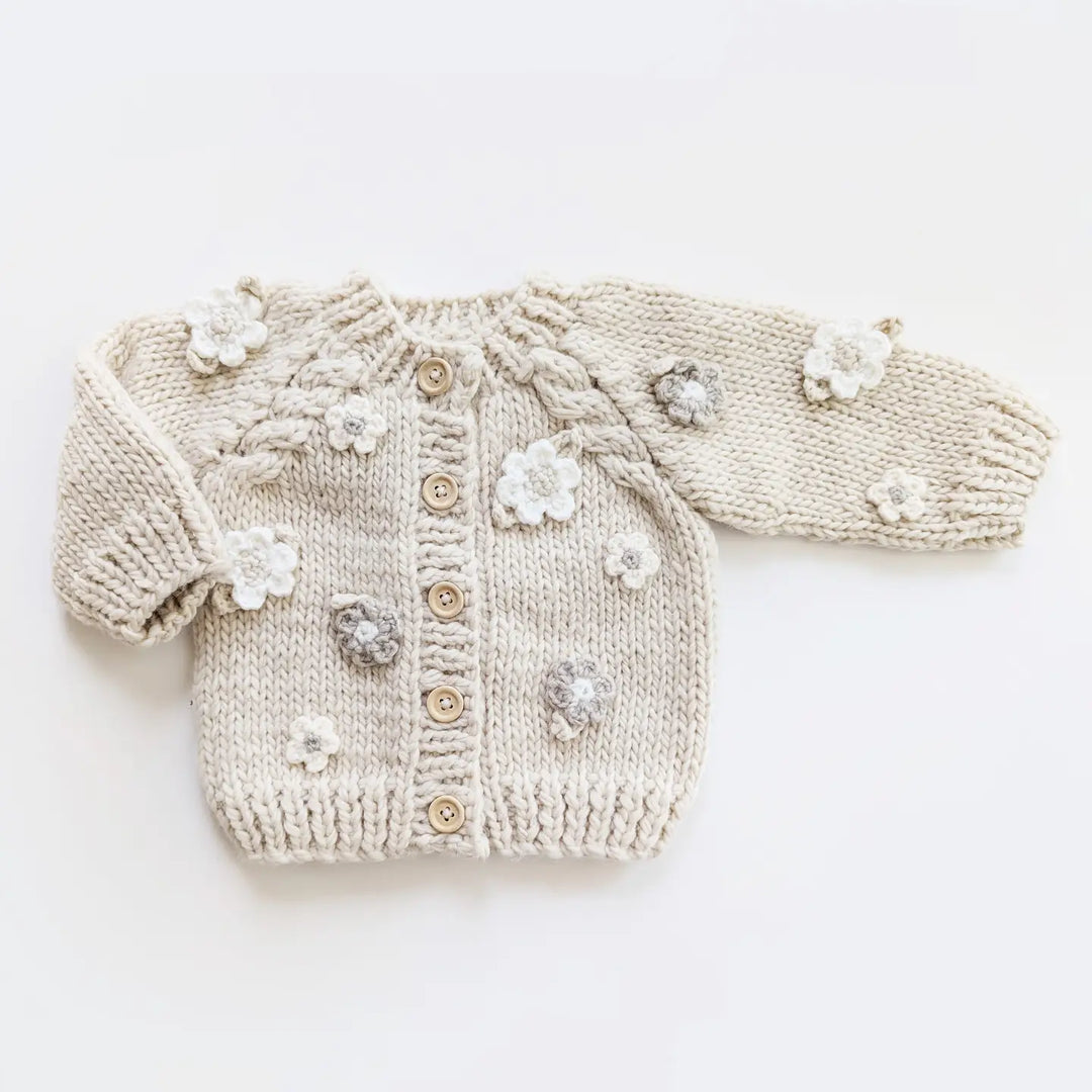Natural hand-knit Blossom Baby Cardigan with crocheted flowers, cabled raglan sleeves and wood buttons