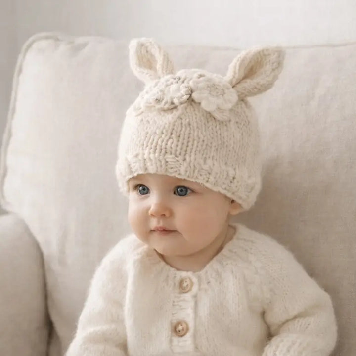Baby wearing the natural Blossom Bunny Baby Hat with bunny ears and a flower garland