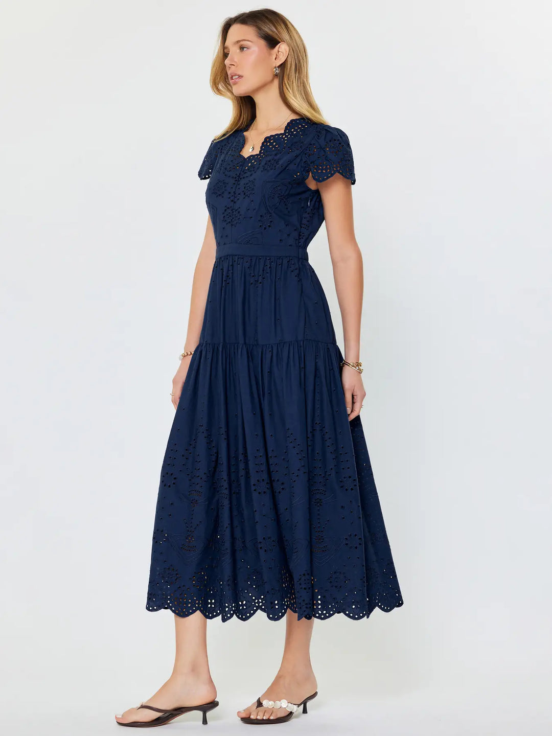 Woman wearing a navy blue lace dress on a white background