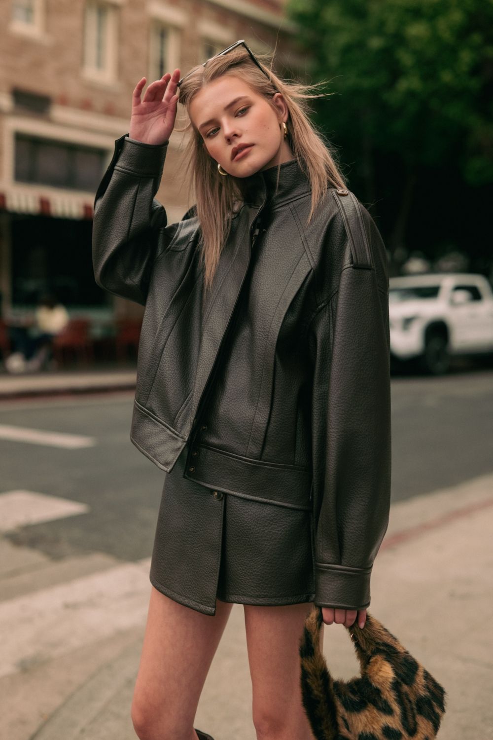 Chocolate Faux Leather Jacket in chocolate brown, lifestyle front view styled with the matching Chocolate Faux Leather Skort