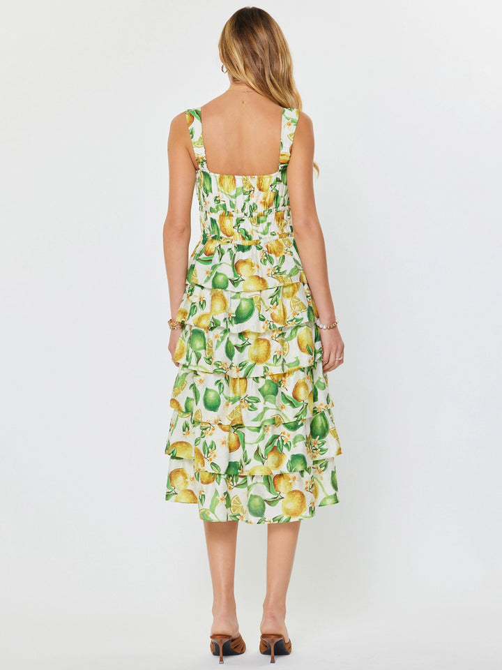 Woman wearing a dress with lemon and lime pattern on a white background
