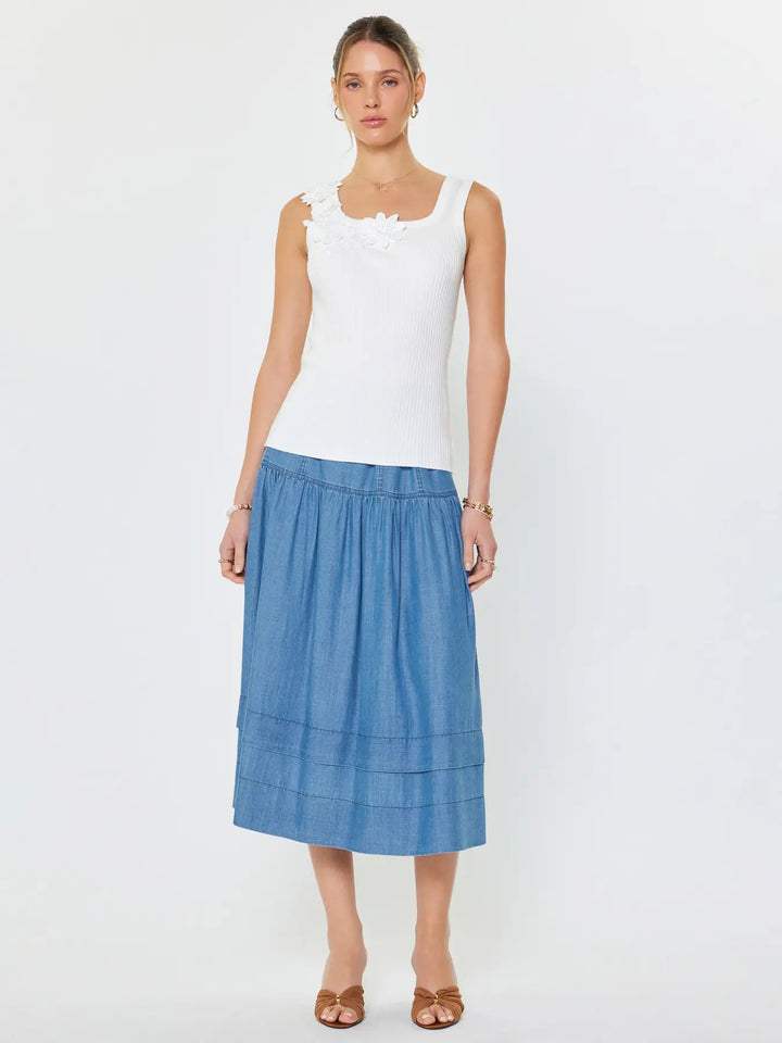 Woman wearing a white top and blue skirt on a white background