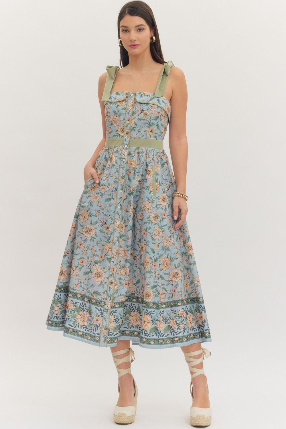 Woman wearing a floral dress with suspenders on a white background